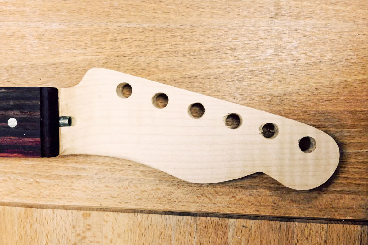 Holes for the tuner pegs are drilled before sealing and finishing the neck with several coats of Liberon boiled linseed oil